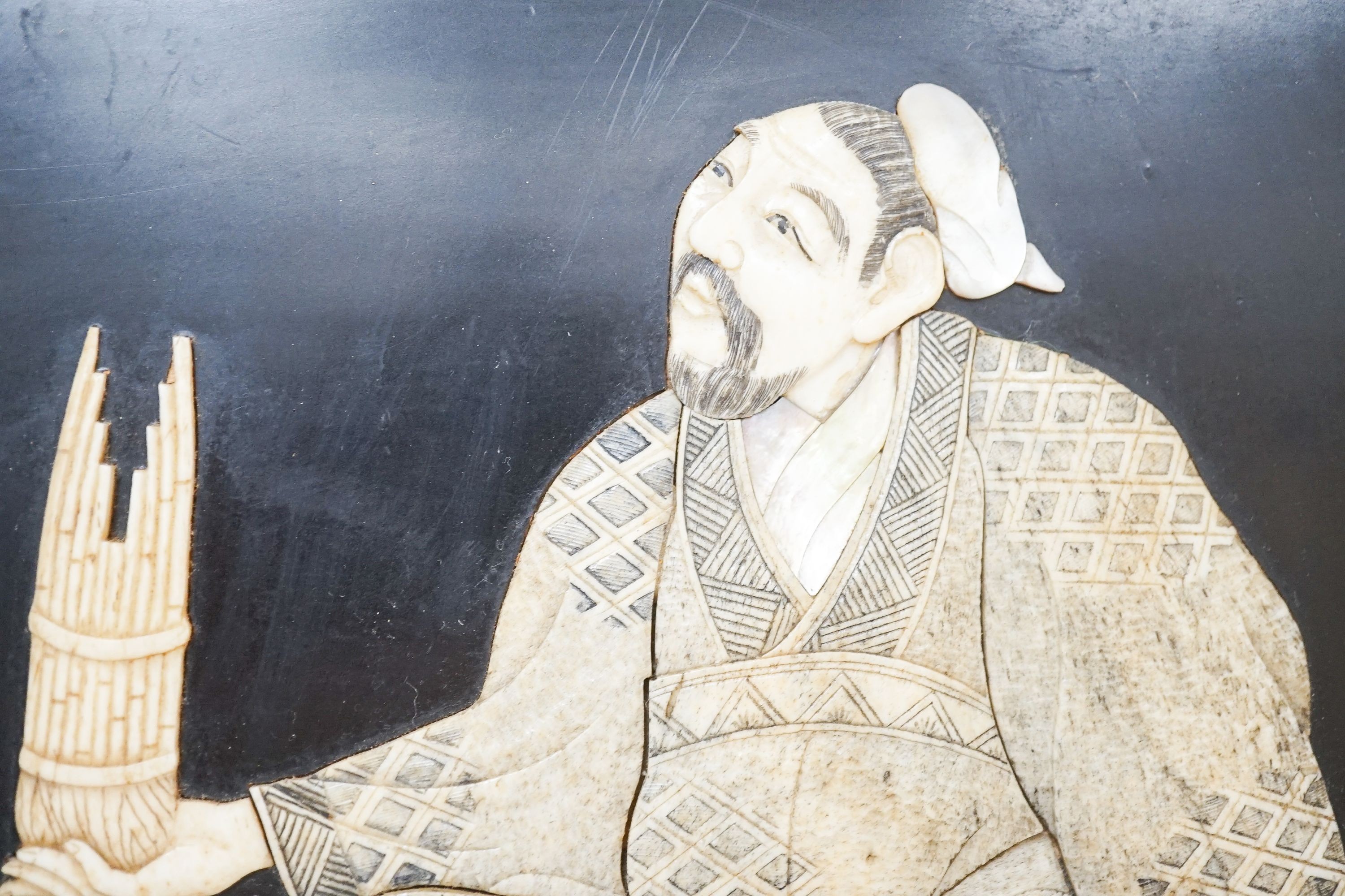 A pair of Japanese Shibayama style ivory, bone and mother of pearl inlaid lacquer panels, Meiji period, depicting two seated men, the other a bijin, 30 x 45cm